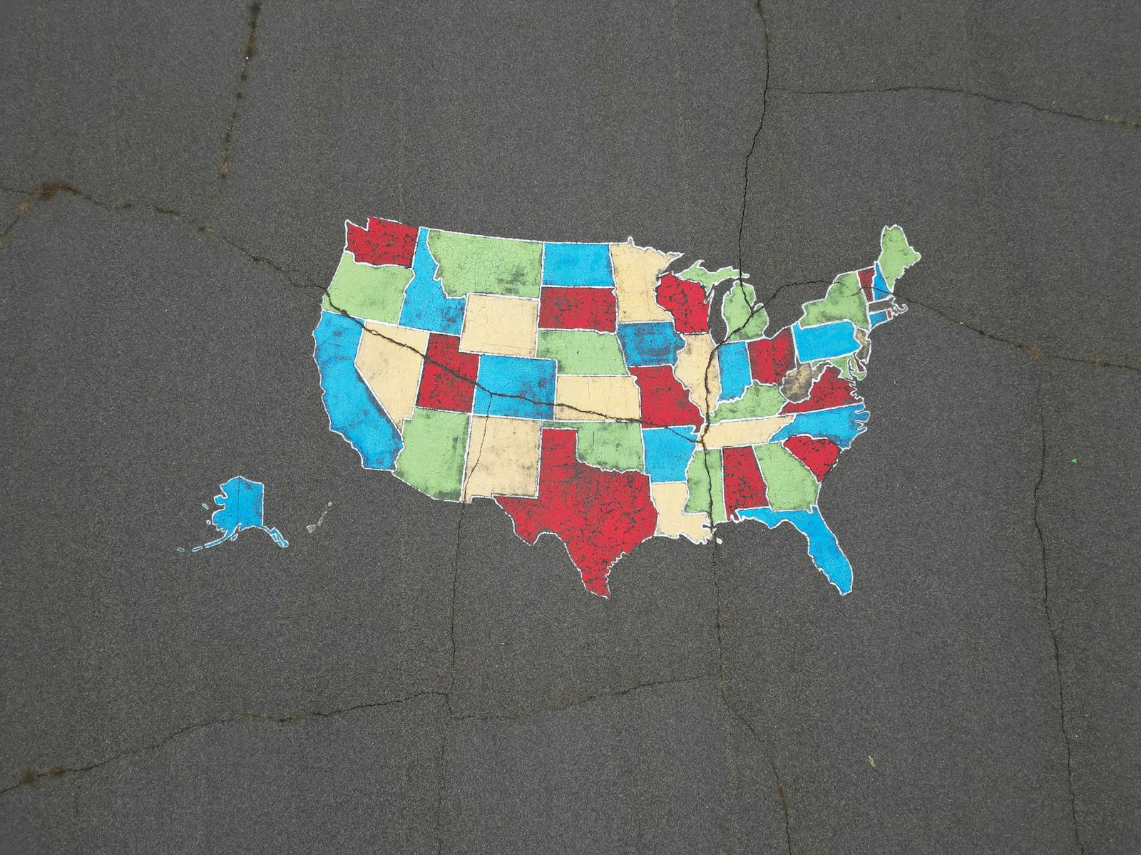 Vibrant map of the USA painted on pavement, showcasing bold state colors.